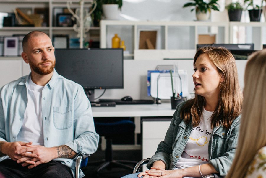 Man sitting listening to woman speak